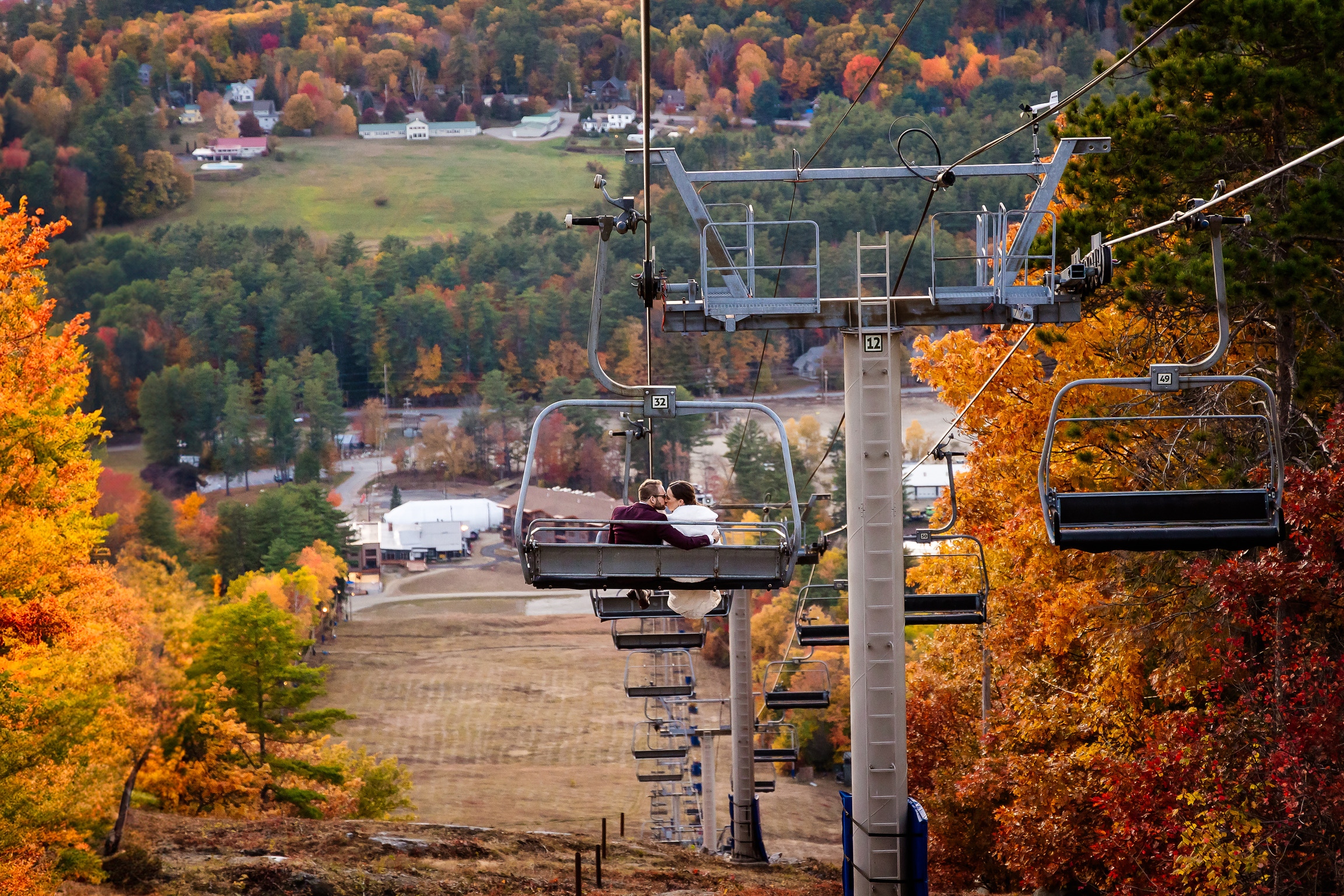 Couple riding chairlift in foliage