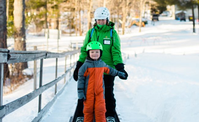 child and instructor riding the magic carpet