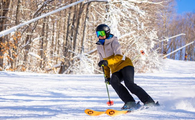 Skier in Gold Arc'teryx Jacket making pole plant