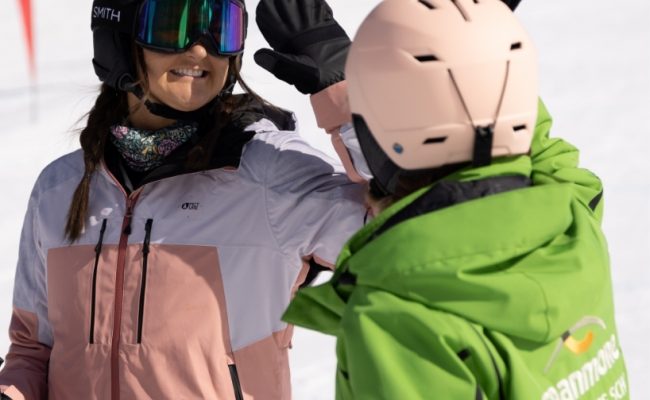 Skier and instructor giving high five